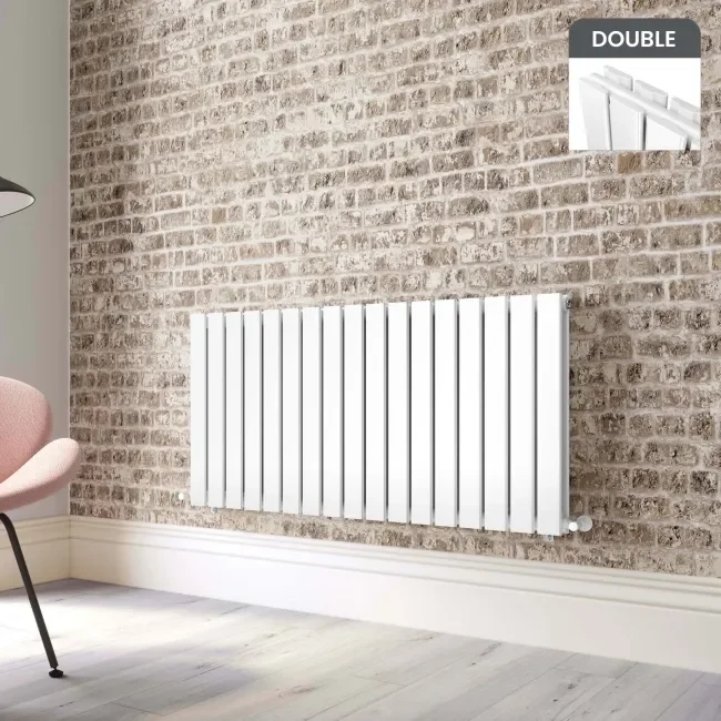 Modern white radiator installation on brick wall